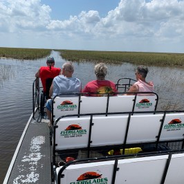 a group of people riding on the back of a boat in the water